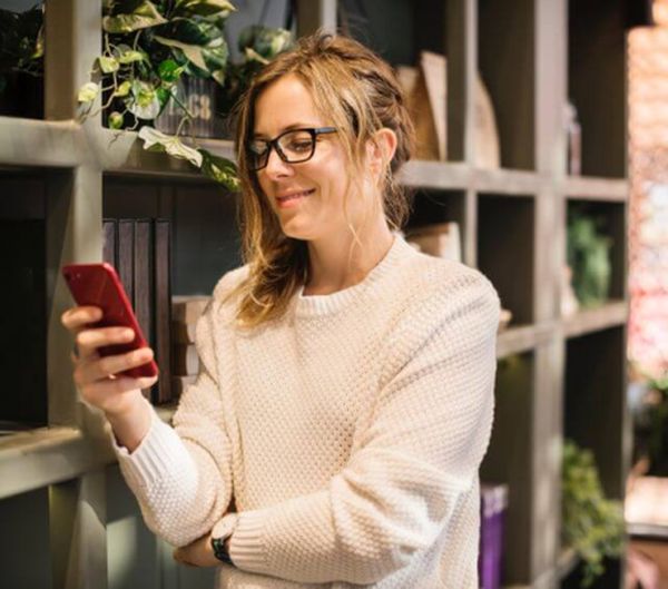 Frau lächelt auf ihr Handy