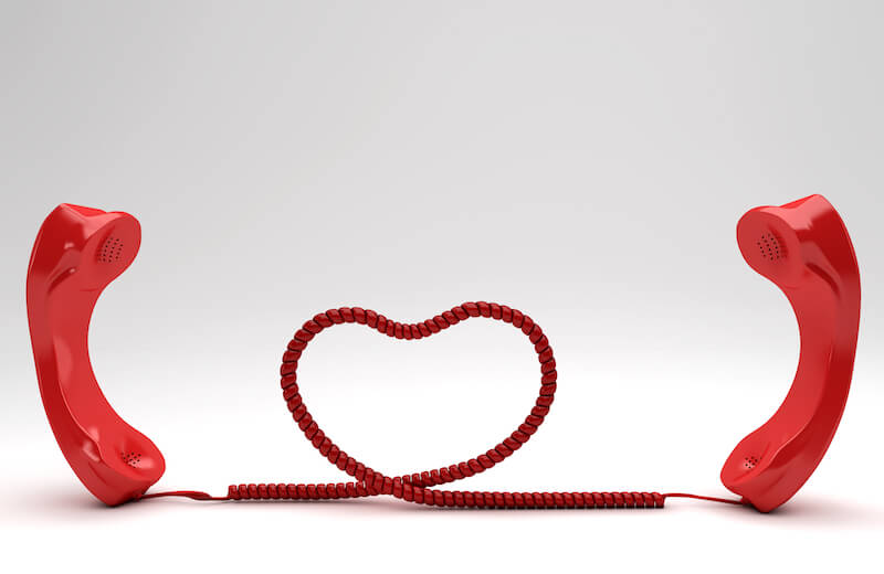 Zwei rote Telefone formen Schnur zum Herzen